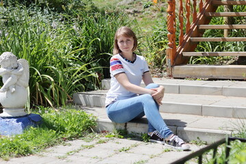 a woman sits on the steps in a park