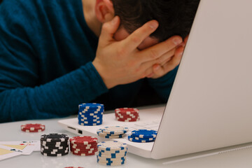 Devastated gambler man losing a lot of money playing poker in casino, gambling addiction. Divorce, loss, ruin, debt, ludopata concept.