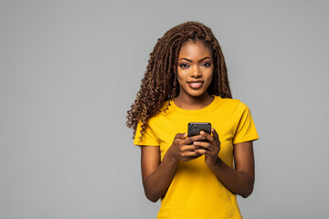 Young woman texting on her phone isolated over white background