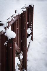 Valla de madera marrón cubierta de nieve en un paisaje nevado