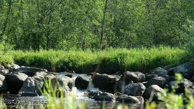 Beautiful waterfall on a flat river. Big rocks.