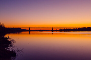 Fototapeta na wymiar Bridge at sunset. Steel bridge over the Tagus river in Chamusca, Portugal