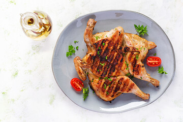 Grilled chicken Tabaka on blue plate. Georgian cuisine. Top view, above