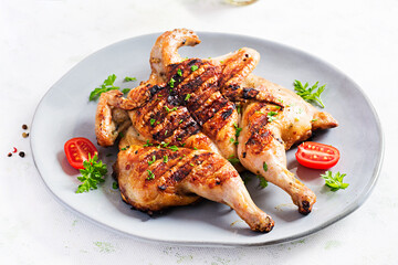 Grilled chicken Tabaka on blue plate. Georgian cuisine.