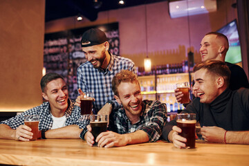 Football fans watching TV. Group of people together indoors in the pub have fun at weekend time