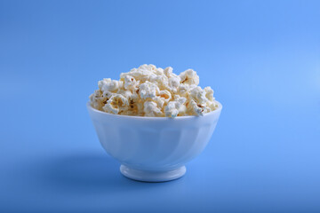 Popcorn in bowl on a blue background. Close up. Top view