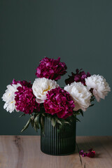 A bouquet of colorful peonies in a vase.