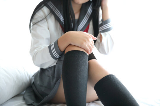 Portrait japanese school girl sitting in white tone bedroom © Oran Tantapakul