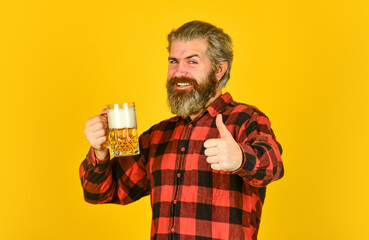Fototapeta premium craft beer. Man drinking in pub bar. Beer with foam. brutal hipster drink beer. mature bearded barman hold beer glass. confident bartender raising toast. leisure and celebration