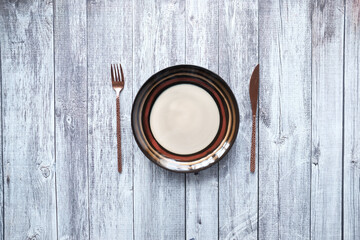 Fototapeta na wymiar cutlery and empty plate on wooden background top down