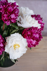 A bouquet of colorful peonies in a vase.