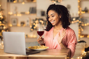 Black woman having dinner drinking wine making videocall