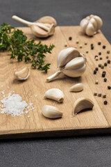 Fototapeta na wymiar Heads and cloves of garlic, allspice and salt on cutting board