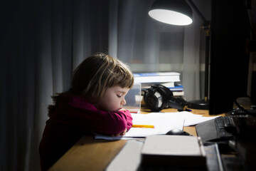 tired child using a computer and study online at home late at night. homeschooling, distant learning.