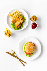 Fast food flat lay set. Burger with fried potatoes and chicken, top view
