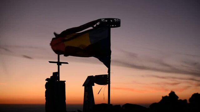 Romanian flag waving on top of the Parang mountain at sunset. drapel in three colors