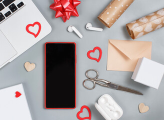 Red Mobile phone and valentines day decorations near laptop