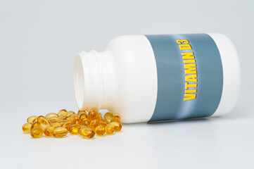 Vitamin d3 bottle with scattered softgel. Isolated on white background. Healthy immune system.