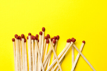 matches are piled on a yellow background close-up.