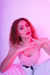 Portrait of young asian woman in pink cloth and white sporty pant in studio light background.