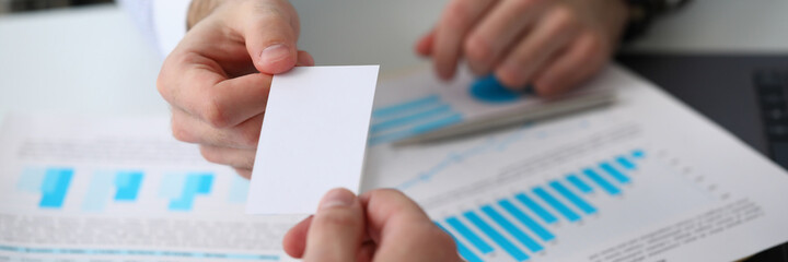 Top view close up of male hand in shirt sharing contacts on paper to partner