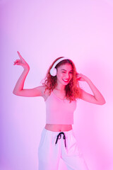 Asian woman wearing headphone and dance in neon light background.