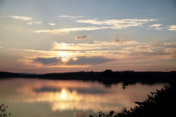 Obraz premium Beautiful lake view during sunset with blue and yellow sky reflection in water. Rural scene. Ecological protection and eco tourism concept. Natural landscape. Isolation in countryside.