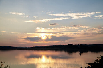 Obraz premium Beautiful lake view during sunset with blue and yellow sky reflection in water. Rural scene. Ecological protection and eco tourism concept. Natural landscape. Isolation in countryside.