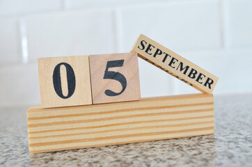 September 5, Cover design with number cube on a white background and granite table.