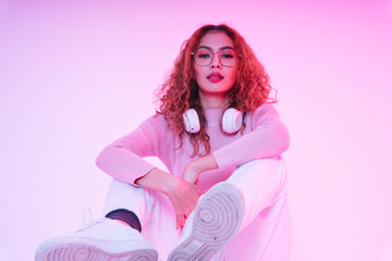 Asian beauty girl curly hair with wireless headphone in neon studio.