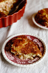 Apple and Cheese Cobbler Crisp. Cobbler or Crumble dessert with apples in ceramic baking form on beige linen table. Selective focus