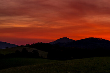 Beskydy mountains Kozlovice landscape with lots of hills and mountains on the horizon and colorful sunset with lots of clouds in the sky.