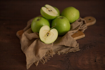 Still-life. Green apples on a wooden board with a napkin.