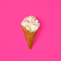 Beautiful delicate white roses in an ice cream Waffle cone isolated on bright pink background. Flat lay valentine day concept