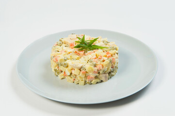 Close up of Russian traditional holiday Olivier salad. Dish of boiled vegetables dressed with mayonnaise sauce. Christmas New Year cold dish served on gray plate. Object isolated on background.
