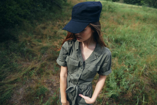 Woman in the forest green jumpsuit black cap nature fresh air green leaves 