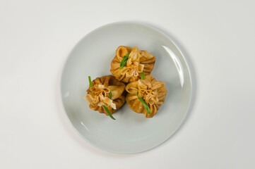 Top view of Holiday Russian starter dish blini with minced meat inside. Traditional crepes appetizer with fresh spring onion scallions. Delicious new year Christmas dish
