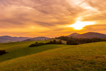 Fototapeta premium Beskydy mountains Kozlovice landscape with lots of hills and mountains on the horizon and colorful sunset with lots of clouds in the sky.