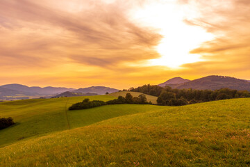 Obraz premium Beskydy mountains Kozlovice landscape with lots of hills and mountains on the horizon and colorful sunset with lots of clouds in the sky.