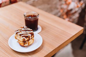 A plate of mini cinnamon rolls and a cup of black coffee