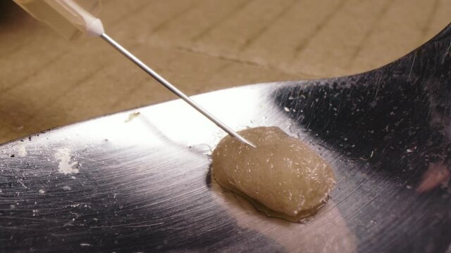 Closeup Syringe needle extracting heroin from a spoon after cooking using filter