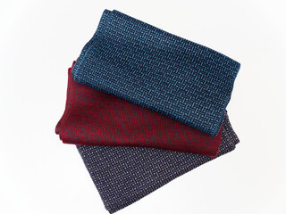 Three colored warm woolen scarves on a white background.