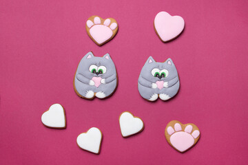 Valentine cookies in form of cats on purple colored paper background