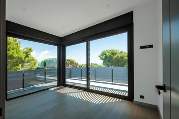Fototapeta premium Empty room with large panoramic windows overlooking the sea. Room after major renovation.