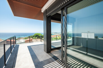 Sea view from a large terrace with a glass partition.