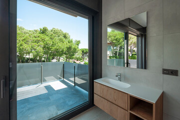 Fototapeta na wymiar Modern bathroom with large window with modern washbasin.