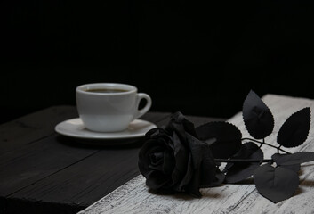 White coffee cup on black background and black rose on white background
