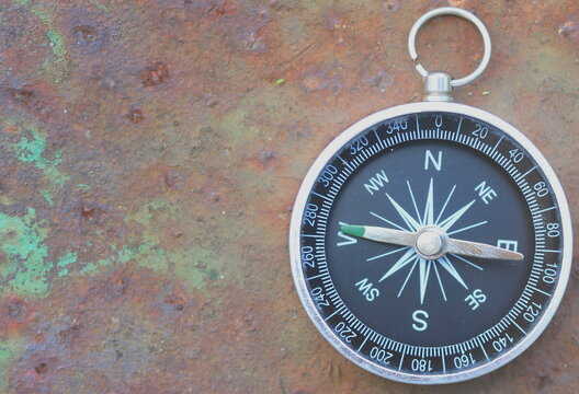 round compass on rusty background as symbol of tourism with compass, travel with compass and outdoor activities with compass