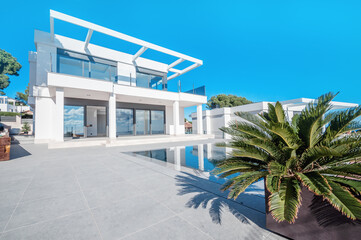 The modern facade of a luxury villa with a large swimming pool. Luxury MODERN property.