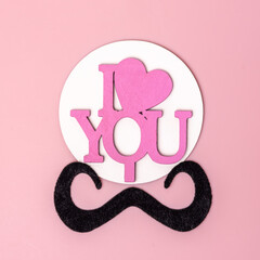 Creative man face made of mustache and inscription I love you. Minimalistic Valentine day card. Flat lay, top view.